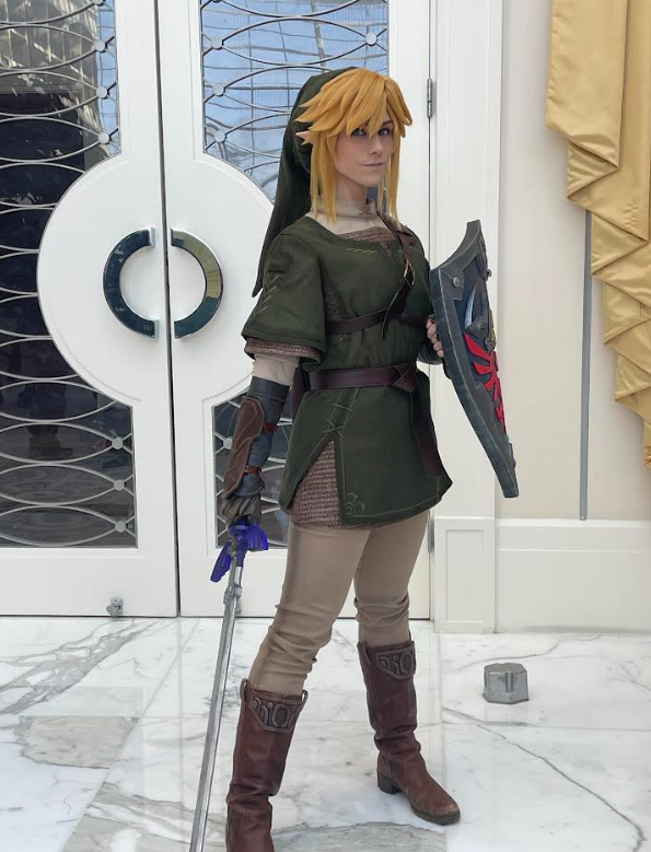 The cosplayer Bukkitbrown posing as Link from The Legend of Zelda, holding the Hylian shield